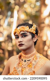 Asian Men Wearing Black Eyeshadow And Red Black Lips On Her Face While Wearing A Gold Crown On The Head Inside The Village