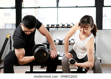 Asian Men And Women With Dumbbells In The Training Gym