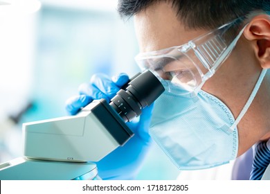 Asian Microbiologist Biotechnology Researcher Or Medical Worker Look Microscope In The Lab