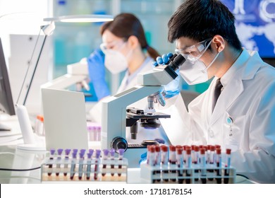 Asian Microbiologist Biotechnology Researcher Or Medical Worker Look Microscope In The Lab