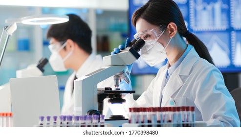 Asian Microbiologist Biotechnology Researcher Or Medical Worker Look Microscope In The Lab