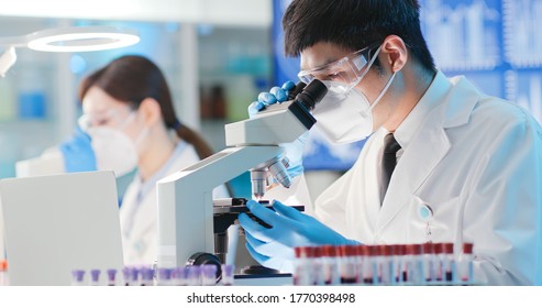 Asian Microbiologist Biotechnology Researcher Or Medical Worker Look Microscope In The Lab