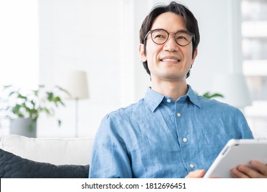 Asian Middle Age Man Who Uses Tablet Computer