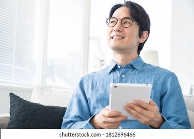 Asian Middle Age Man Who Uses Tablet Computer