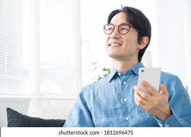 Asian Middle Age Man Who Uses Smart Phone