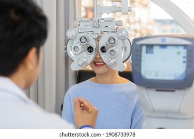 asian middle age woman eye exam with diagnostic ophthalmology in optical clinic. professional ophthalmic checking vision of patient. phoropter machine, Eye health check and ophthalmology concept.