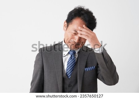 Asian middle aged businessman having trouble in whited background