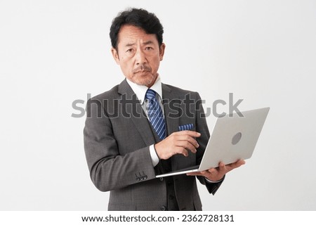 Asian middle aged businessman using the laptop in white background