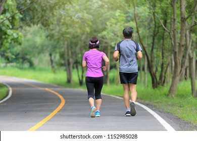 Asian Middle Aged Couple Jogging And Running In Park