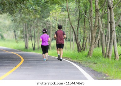 Asian Middle Aged Couple Jogging And Running In Park