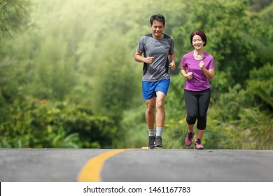 Asian Middle Aged Couple  Jogging Exercise In Park