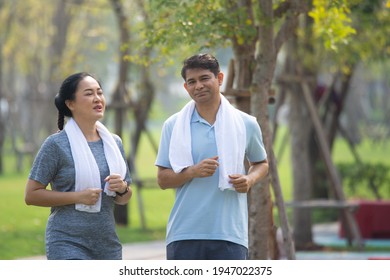 Asian Middle Aged Couple Jogging, Asian Man Women Running Jogging Exercise In City Park On Morning