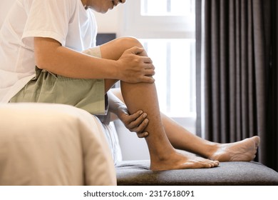 Asian middle aged man have severe cramp his calf of leg,muscle strain,adult male massaging leg with his hands,suffering from muscle cramps,contraction of muscles or tendons,physical injury,health care - Shutterstock ID 2317618091
