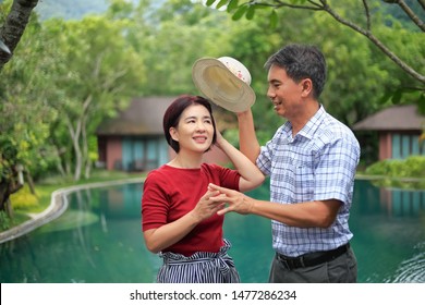 Asian Middle Aged Man Relaxing With His Wife In Anniversary Wedding Day