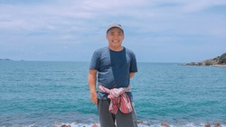 Asian Middle Aged Man Is Taking His Vacation Near The Seabeach Happily, Soft Focus, Concept For Happy Life Of Middle Aged Human Around The World.