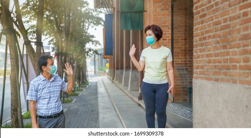 Asian Middle Aged People Wearing Mask And Keep Social Distancing To Avoid The Spread Of COVID-19