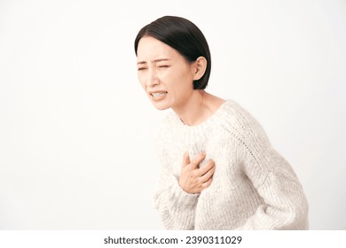 Asian middle aged woman having a palpitation of the heart in white background