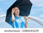 Asian middle aged woman holding a parasol outdoors