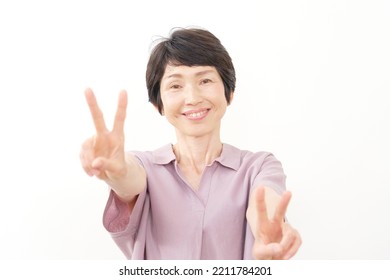 Asian Middle Aged Woman Peace Sign Gesture In White Background