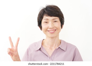 Asian Middle Aged Woman Peace Sign Gesture In White Background