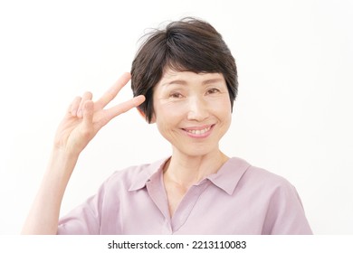 Asian Middle Aged Woman Peace Sign Gesture In White Background