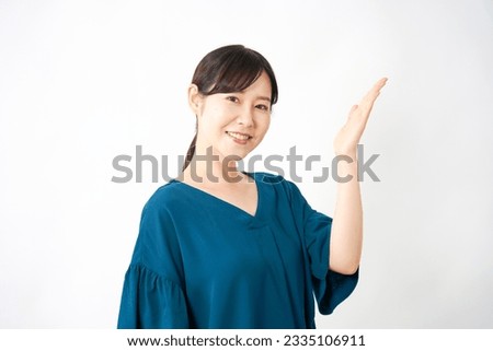 Asian middle aged woman pointing side in white background