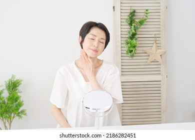 Asian Middle Aged Woman Taking Care Of Her Neck At Home