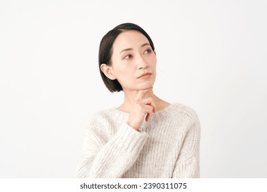 Asian middle aged woman thinking in white background - Powered by Shutterstock