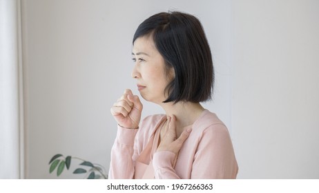 Asian Middle Woman Coughing At Home