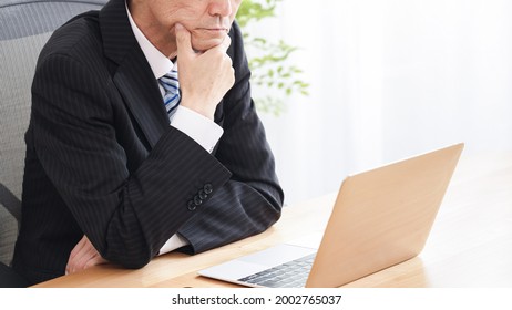 Asian middle-aged businessmen using personal computer - Shutterstock ID 2002765037