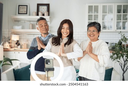 Asian middle-aged couple, with daughter, joyfully play dancing music dance trends Viral on social media. - Powered by Shutterstock