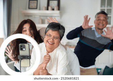 Asian middle-aged couple, with daughter, joyfully play dancing music dance trends Viral on social media. - Powered by Shutterstock