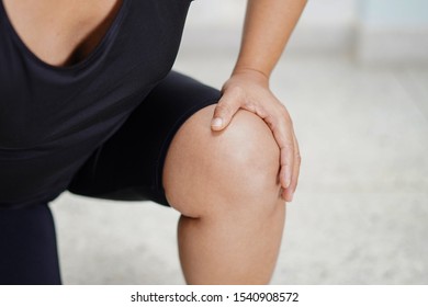 Asian middle-aged lady woman patient touch and feel pain her knee : healthy medical concept.
