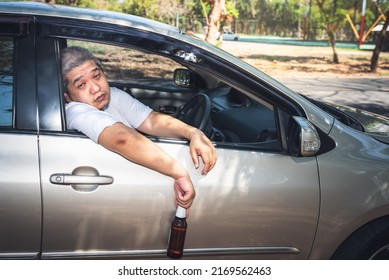Asian middle-aged man are intoxicated by drinking alcohol while driving,  concept to the cause of accidents on the road. - Powered by Shutterstock