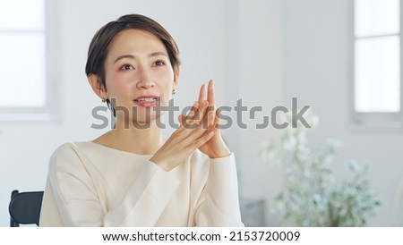 Asian middle-aged woman talking in the room.