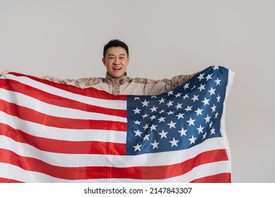 Asian Military Man Smiling While Posing With American Flag Isolated Over White Background