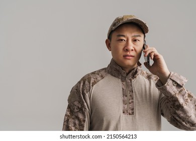 Asian Military Man Wearing Uniform Talking On Mobile Phone Isolated Over White Background