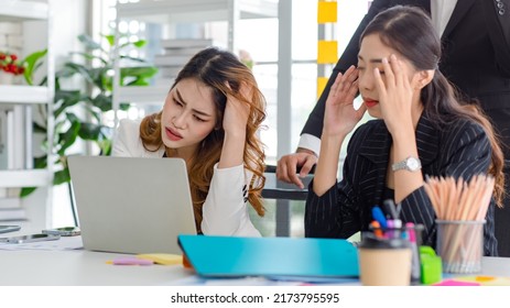 Asian Millennial Professional Successful Male Businessman Mentor In Black Formal Suit Standing Helping Two Female Employee Sitting Working With Laptop Computer At Workstation In Company Meeting Room.