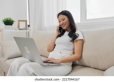 Asian Millennial Woman Sitting With Laptop And Talking On Phone Freelance Student With Looking At Laptop Screen Working, Lifestyle Work And Home