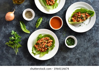Asian minced meat lettuce wraps on blue stone background. Top view, flat lay