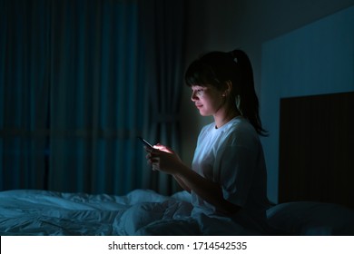 Asian mobile addict woman using smaryphone browsing the internet for watching movie or virtual meeting video call online with boyfriend on the bed before she sleeping at night.
 - Powered by Shutterstock