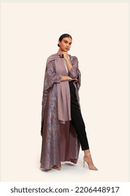 Asian Model Poses For Arabic Designer Abaya On Isolated Background. Fashion Concept