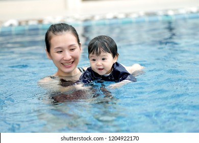 Asian Mom And Baby Are Swimming In A Pool With Great Happiness