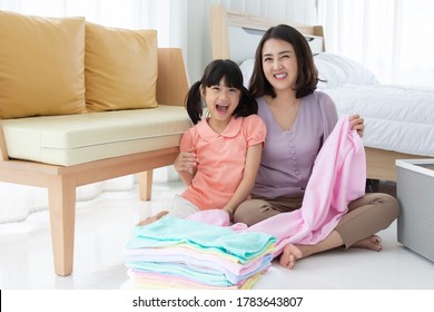 Asian Mom And Daughter Doing Laundry At Home