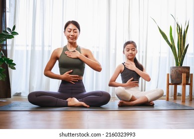 Asian Mom And Her Girl Setting Prepare To Yoga And Meditation Pose Together On Yoga Mat At Home