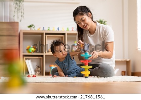 Asian mom teaching baby boy learning and playing toys for development skill at home or nursery room. Happiness mother and baby spending time together at warmth place. Good moment with mom and baby