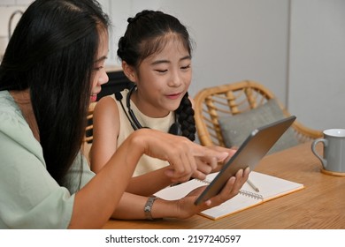Asian Mom using tablet for teaching her school girl at home, Studying online, Online learning, E-learning concept.