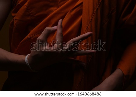 Asian Monk with hand gesture close up shot and shadow