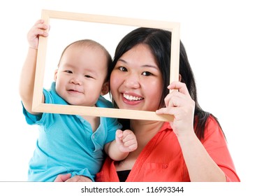 Asian Mother And Baby Boy Looking Fun Through An Empty Frame