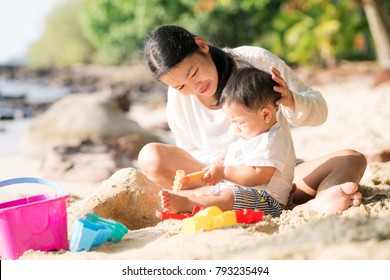 Asian Mother And Baby Play Sand And Toy Togather On Ther Beach